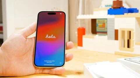 Apple iPhone 15 with Hola text welcome screen. Brand new iPhone in new green Stock Photos