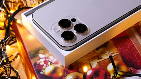 Apple iPhone 16 Pro Max Desert Titanium on Christmas background Stock Footage 323314972
