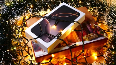Apple iPhone 16 Pro Max Desert Titanium on Christmas background Stock Footage 323315013