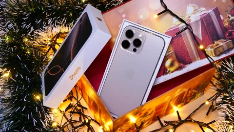 Apple iPhone 16 Pro Max Desert Titanium on Christmas background Stock Footage 323315051