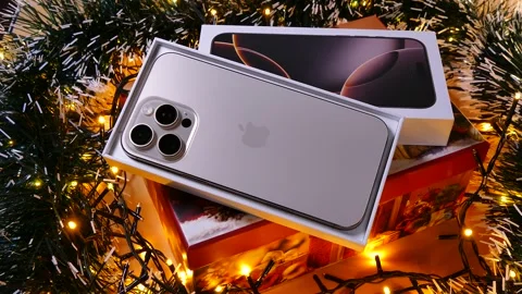 Apple iPhone 16 Pro Max Desert Titanium on Christmas background Stock Footage 323315057
