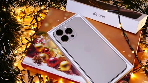 Apple iPhone 16 Pro Max Desert Titanium on Christmas background Stock Footage 323315090