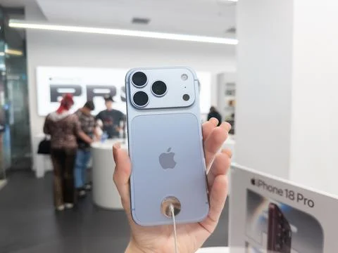 Apple iPhone 18 Pro in Glacier color held in hand at a retail store, showcasing Stock Photos
