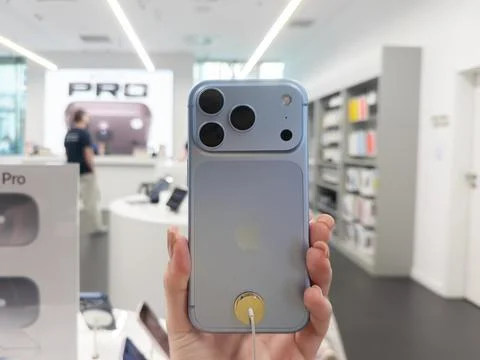 Apple iPhone 18 Pro Glacier color held in a hand inside a retail store, Stock Photos