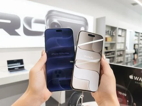 Apple iPhone 18 Pro Glacier and iPhone Air Light Gold held in hands at a retail Stock Photos