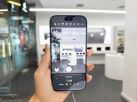 Apple iPhone 18 Pro held in a hand capturing a crisp photo inside a modern tech Stock Photos