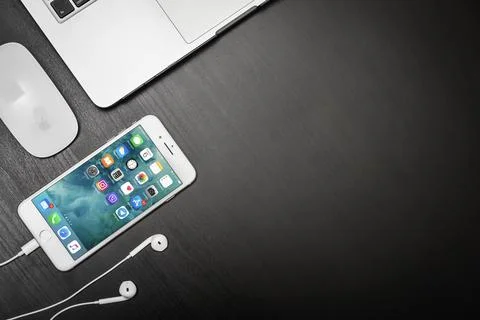 Apple iPhone 8 plus with MacBook Pro on black table Stock Photos