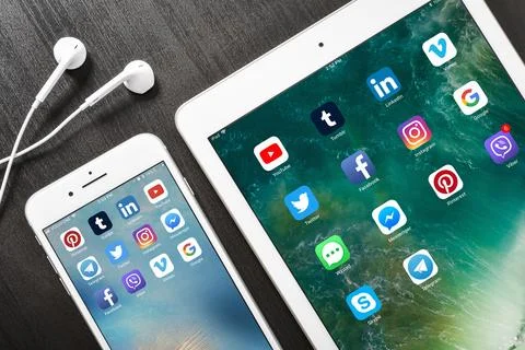 Apple iPhone 8 plus with social network apps on the screen with ipad and he.. Stock Photos