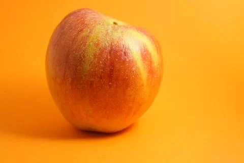 Apple isolated on orange background Stock Photos