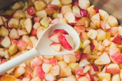 Apple jam making in process, focus on the apple pieces cupping up in the whit Stock Photos