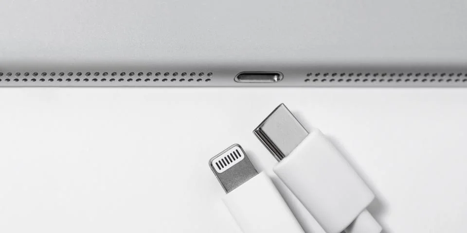 Apple Lightning to USB-C cable and gadget on a white table with empty space,  Stock Photos