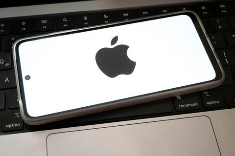 Apple logo on smartphone resting on computer keyboard Stock Photos