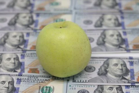 An apple lying on the background of one hundred dollar bills, dollar backgr.. Stock Photos