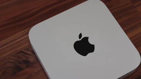 Apple Mac Mini computer in silver with logo on walnut wood desk Stock Footage 265470384