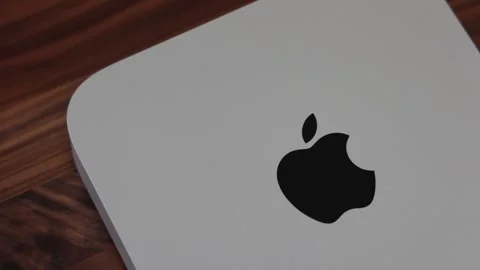 Apple Mac Mini computer in silver with logo on walnut wood desk Stock Footage 265470391