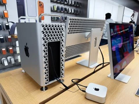 Apple Mac Pro and iMac display setup in tech store with accessories and cable Stock Photos