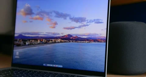 Apple MacBook laptop and Apple HomePod speaker on wooden desk Stock Footage 337244611