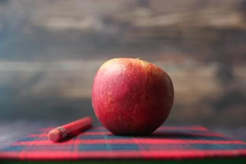 Apple on a notepad on table, back to school concept Stock Photos