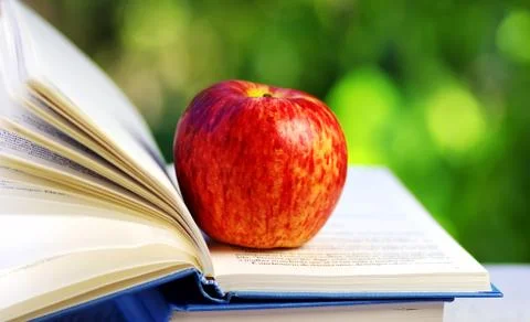 Apple on open book Stock Photos
