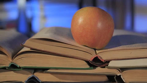 Apple on Open Books Symbolizing Education and Knowledge Vídeo Stock 335151494