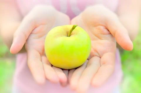 Apple in open hands Stock Photos