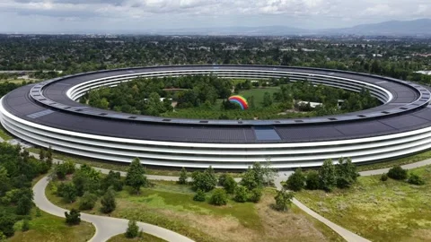 Apple Park circular headquarters dominates lush green campus with rainbow Stock Footage 337052866