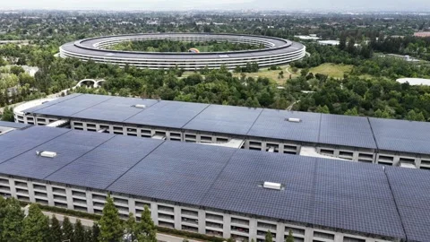 Apple Park ring-shaped headquarters rises above dense green campus beside large Stock Footage 337120838