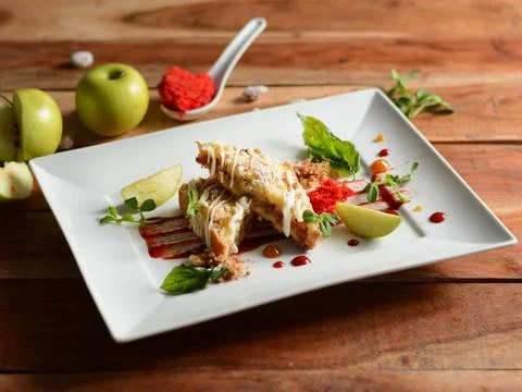 Apple pie with Basil served in a white plate on a rustic wooden table, select Stock Photos