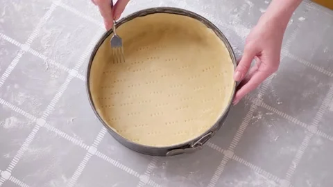 Apple pie cake preparation series - woman making holes in rolled dough in baking Stock Footage 196273938