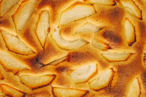 Apple pie close up. Texture of fresh baking. Pieces of fruit in baked dough. Stock Photos