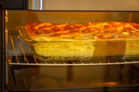 Apple pie in an electric oven with backlight Stock Photos