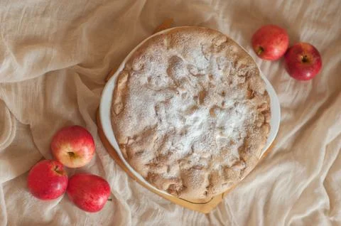Apple pie on a neutral background, apples lie nearby. view from above Stock Photos