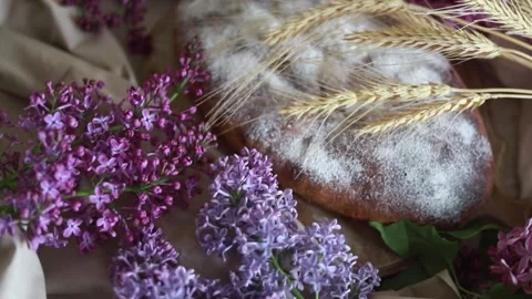 Apple pie next to lilac flowers on a wooden background. Stock Footage 130776148