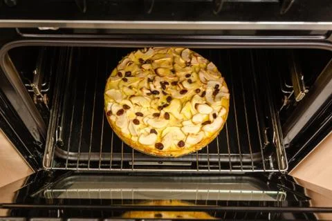 Apple pie in an oven Stock Photos