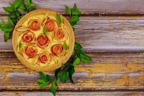 Apple pie rose shape on rustic wooden background. Stock Photos