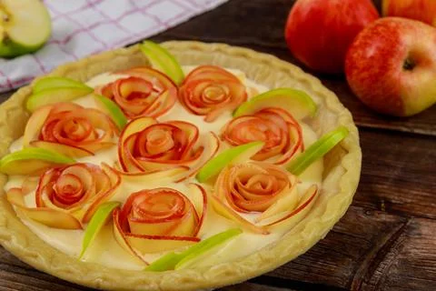 Apple pie rose shape on rustic wooden background. Stock Photos
