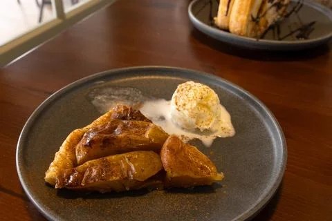 Apple Pie slice with sprinkled cinnamon served with ice cream ball in a plate. Foto stock