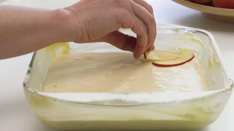 Apple pie step by step recipe. Chef topping pie batter with apple slices Stock Footage 144480115