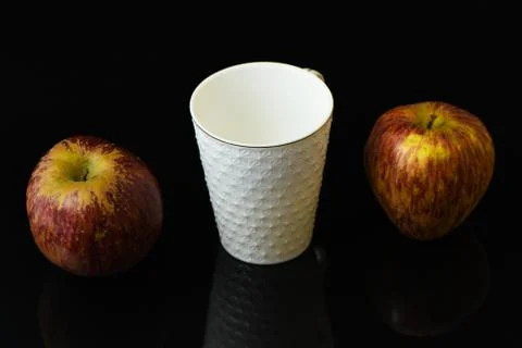 Apple pieces on isolated black background in white glass Stock Photos