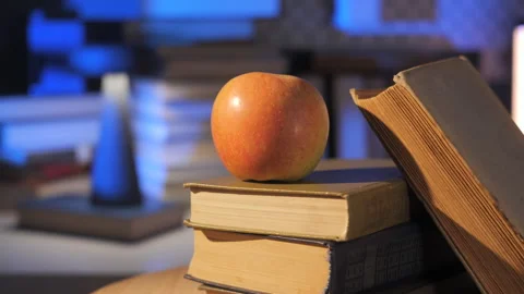 Apple Placed on Stack of Hardcover Books on Table Indoors Stock Footage 325958792