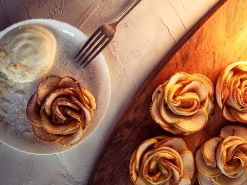 Apple roses, apple buns, serving with whipped cream and almond petals, Stock-Fotos