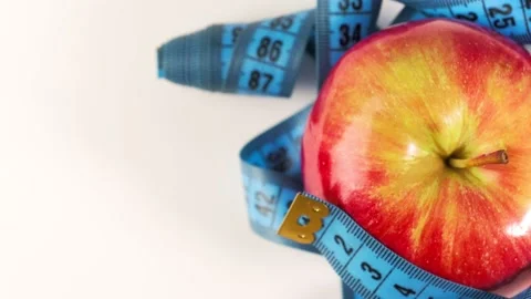 An apple rotates with a centimeter tape, the concept of healthy eating and Stock-Footage 201964356