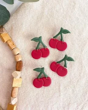 Apple shape red color earring on bed sheet. Modern jewelry earring for wome.. Stock Photos