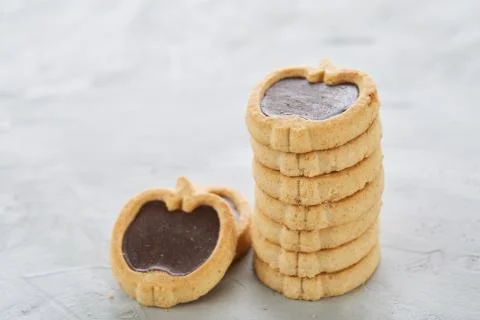 Apple shaped biscuits arranged in rows on light textured background, close-up Stock Photos
