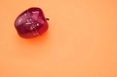 Apple-shaped kitchen timer isolated on orange background Stock Photos