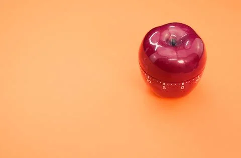 Apple-shaped kitchen timer isolated on orange background Stock Photos