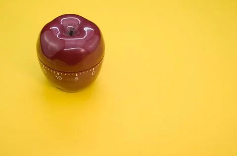 Apple-shaped kitchen timer isolated on yellow background Stock Photos