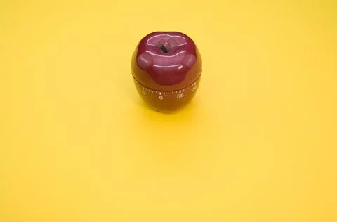 Apple-shaped kitchen timer isolated on yellow background Stock Photos