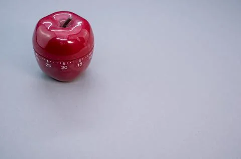 Apple-shaped kitchen timer isolated on light blue background Stock Photos