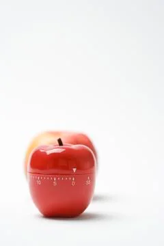 Apple shaped kitchen timer, real apple in background 스톡 사진